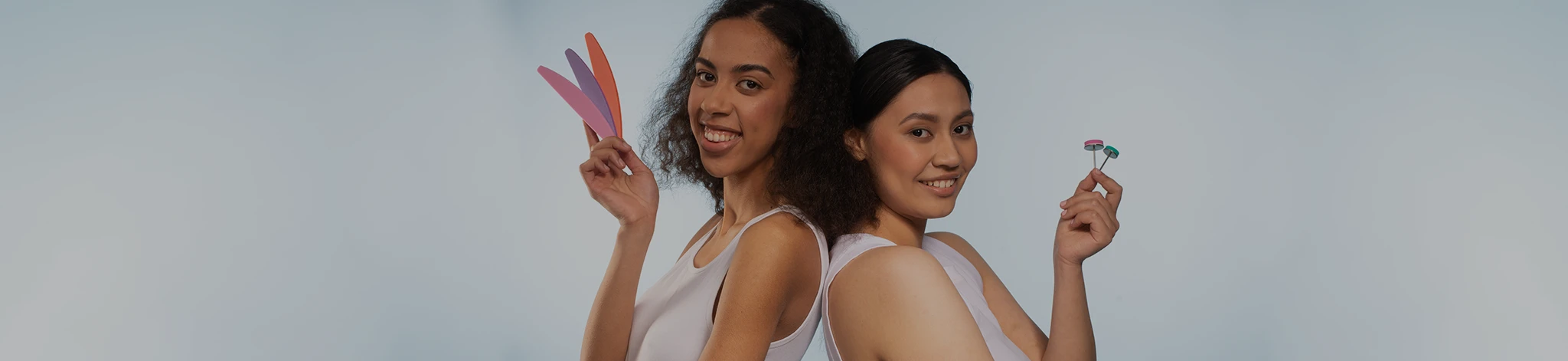 One girl holding Baf Interchangeable nail files and another holding pedicure disc